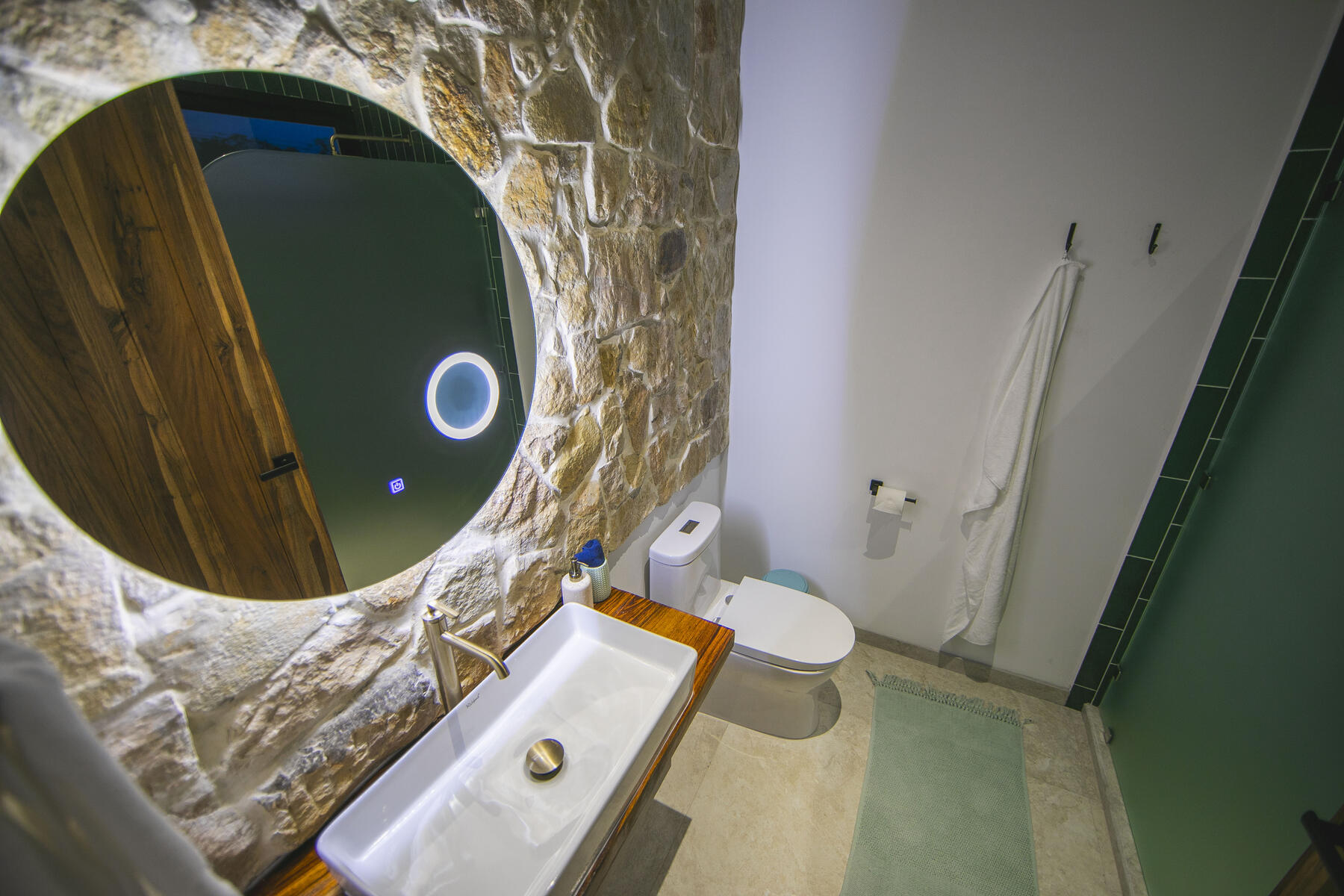 Ensuite bathroom with round window and stone wall